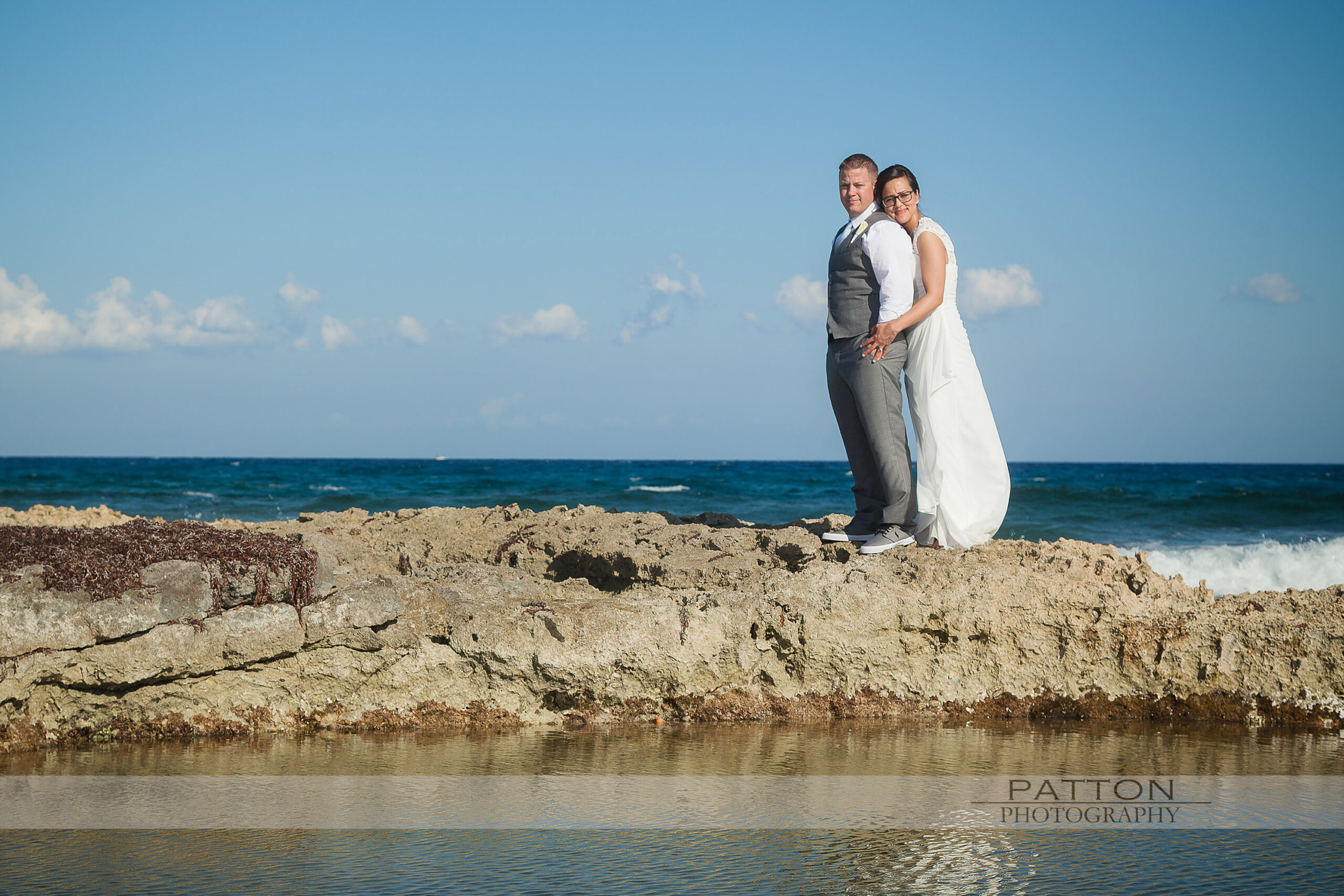 Bride and Groom standing on rocks at a destination wedding
